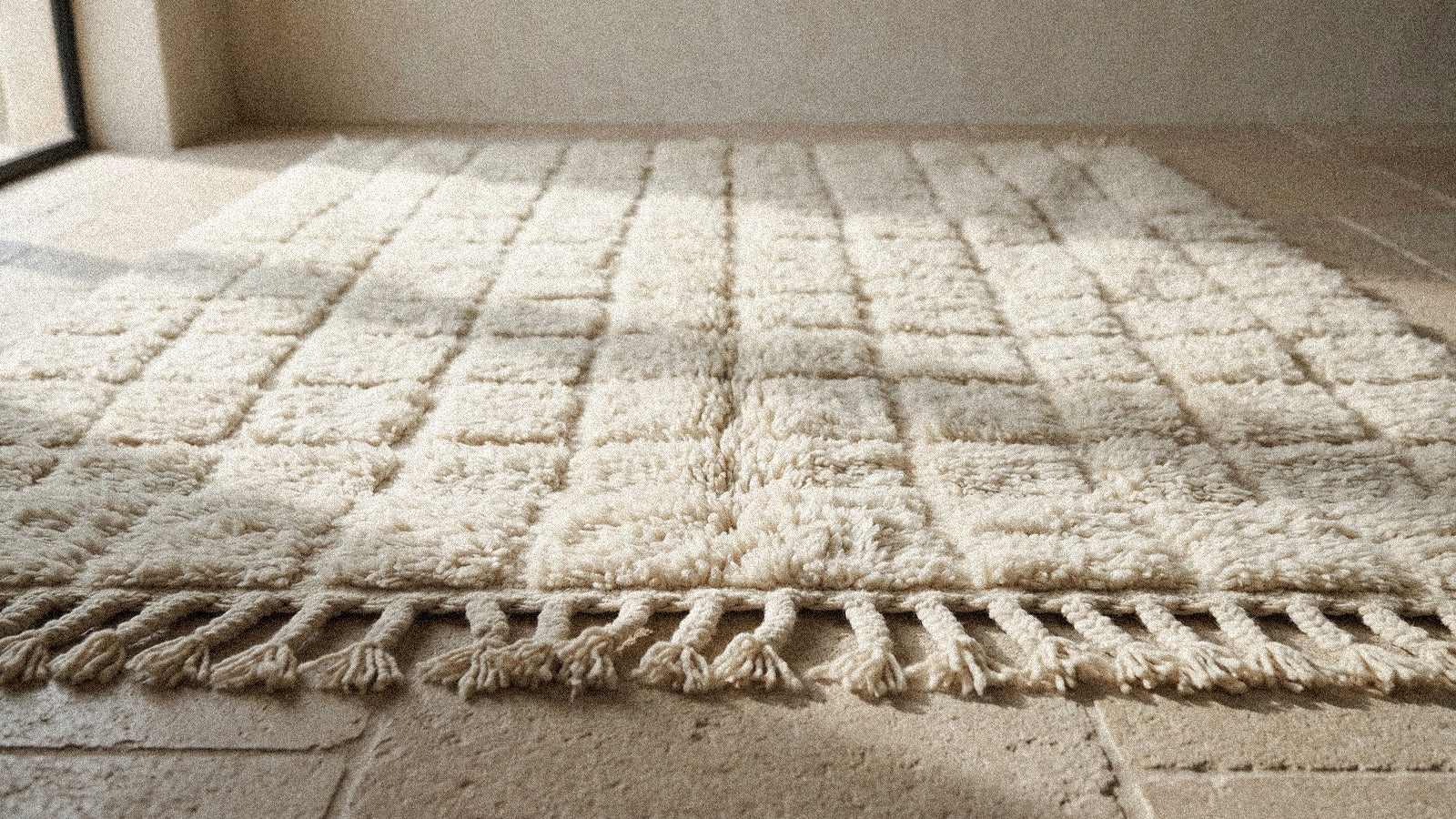Tapis berbère en laine naturelle mettant en valeur la matière filée à la main