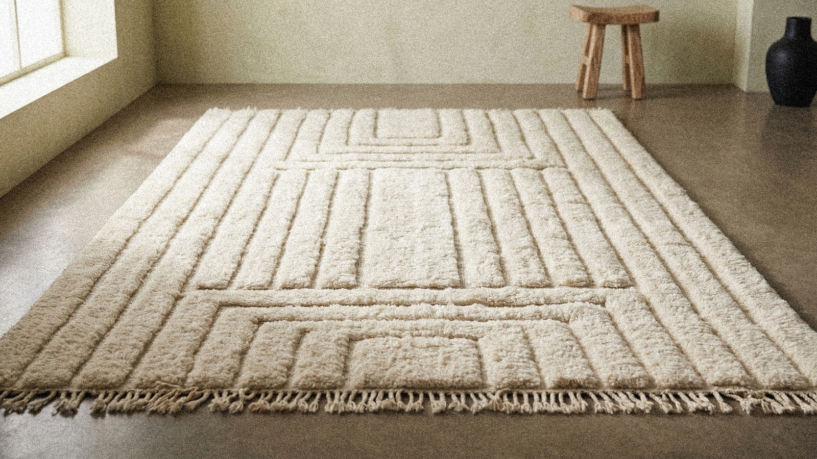 Tapis berbère fait main aux irrégularités assumées dans un intérieur épuré