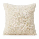 Coussin berbère ASMUN en laine écru, shaggy, sur fond blanc